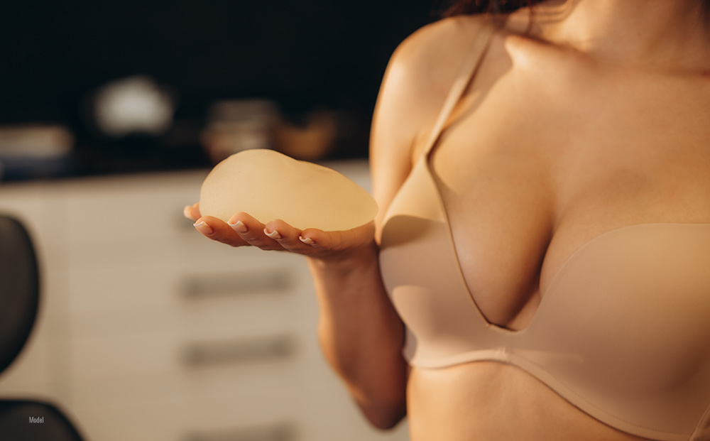 Female holding breast implant in her one hand